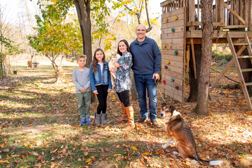 family portrait in backyard with cat and dog